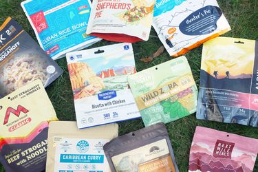 lineup of freeze dried backpacking food pouches on grass