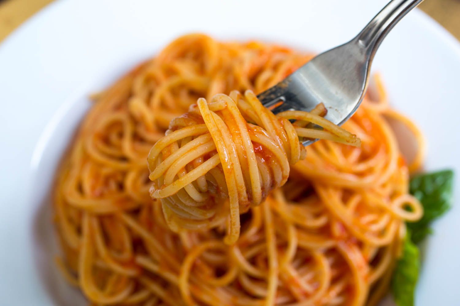 拌有新鲜番茄酱的意大利面在叉子上旋转。