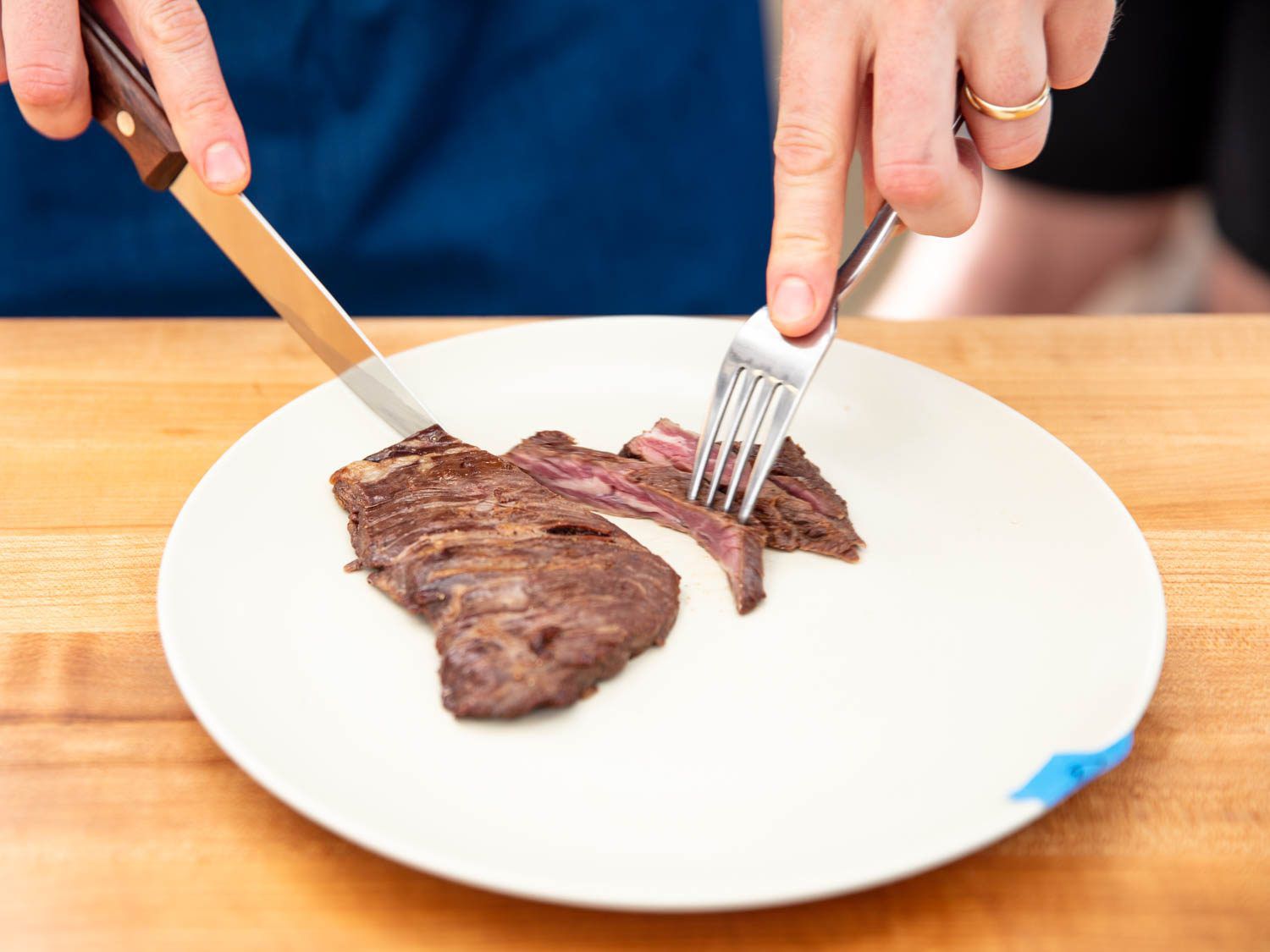 用牛排刀切成一块半熟的牛排。