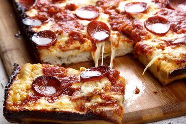 底特律风味的意大利辣香肠披萨放在砧板上