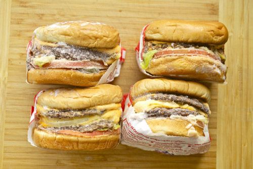 Four frozen In-N-Out burgers with wrappers