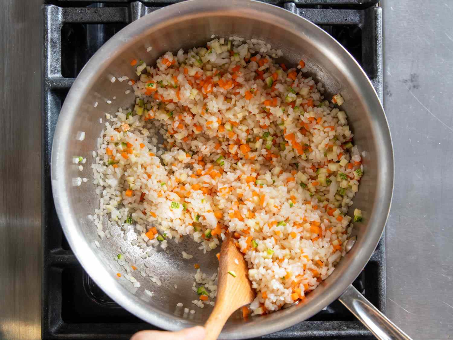 Mixing rice and finely minced vegetables together for Korean juk