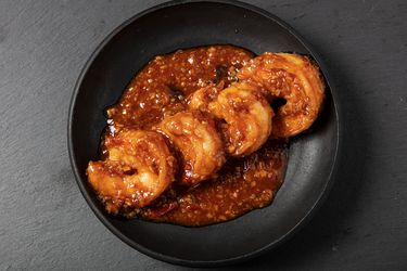 Ebichiri shrimp served on a black round plate.