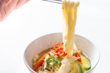 一碗韩国刀切面条汤,筷子下面提高面条的碗。gydF4y2Ba