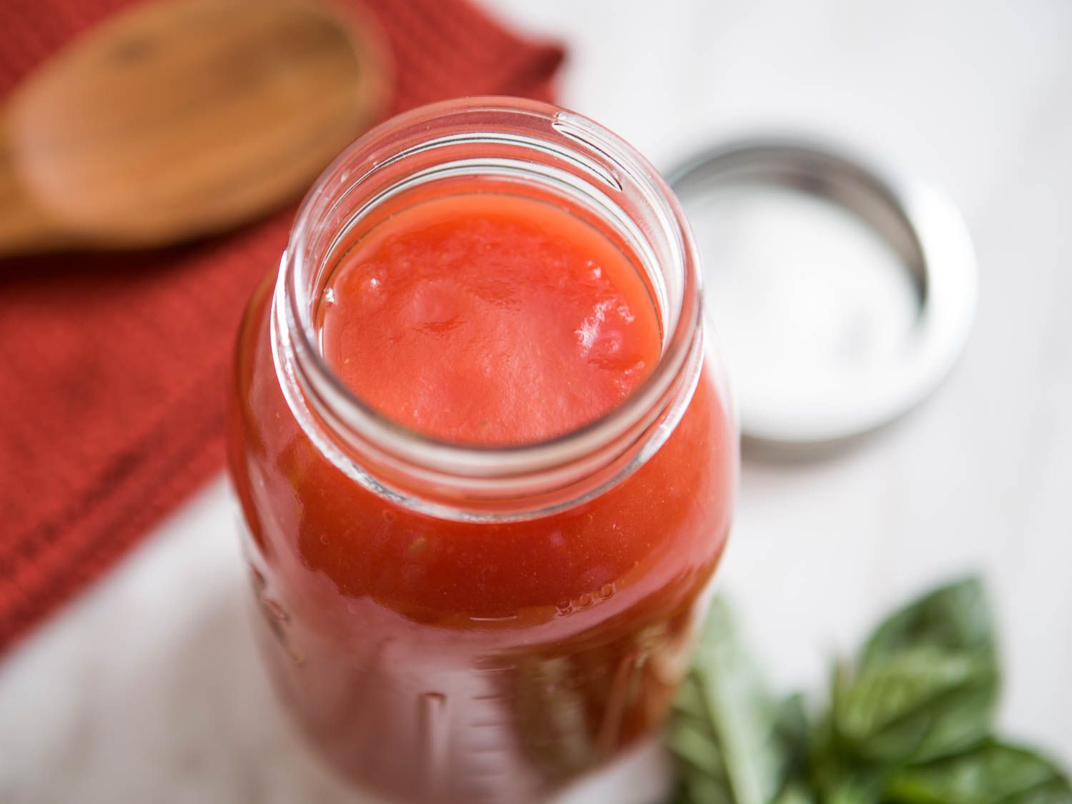 头顶上的一个打开的罐子装满了快熟的西红柿purée。
