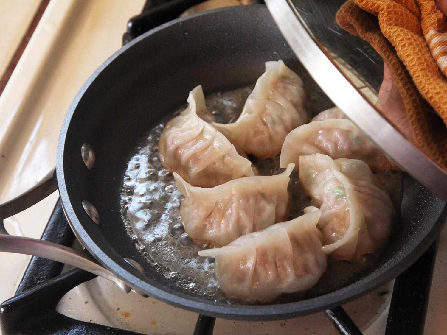 揭开一锅蒸猪肉卷心菜煎饺的盖子。