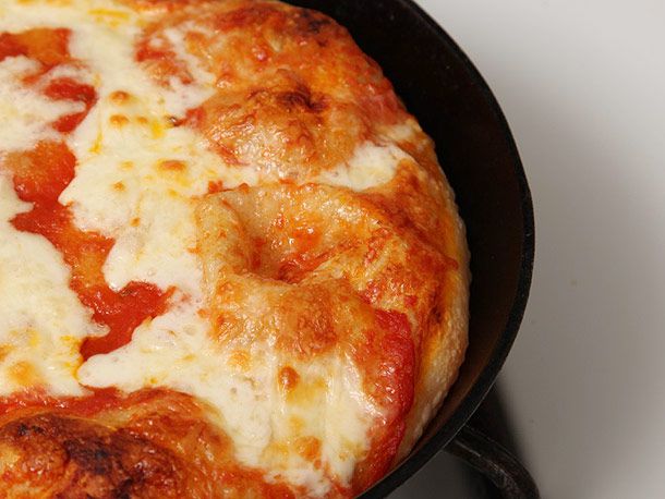 披萨在铸铁锅里烤，配番茄酱和白奶酪。gydF4y2Ba