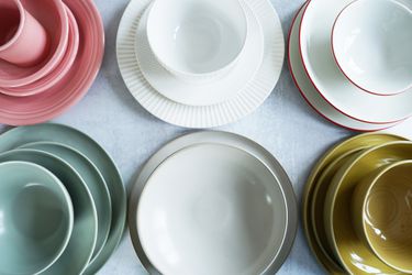 Several dinnerware place settings on a grey surface