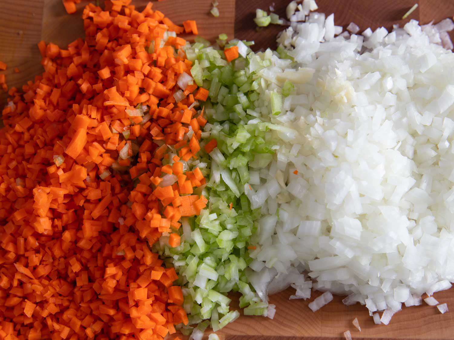 开云体育波胆麦地痘的成分;把胡萝卜、芹菜和洋葱切丁放在砧板上。