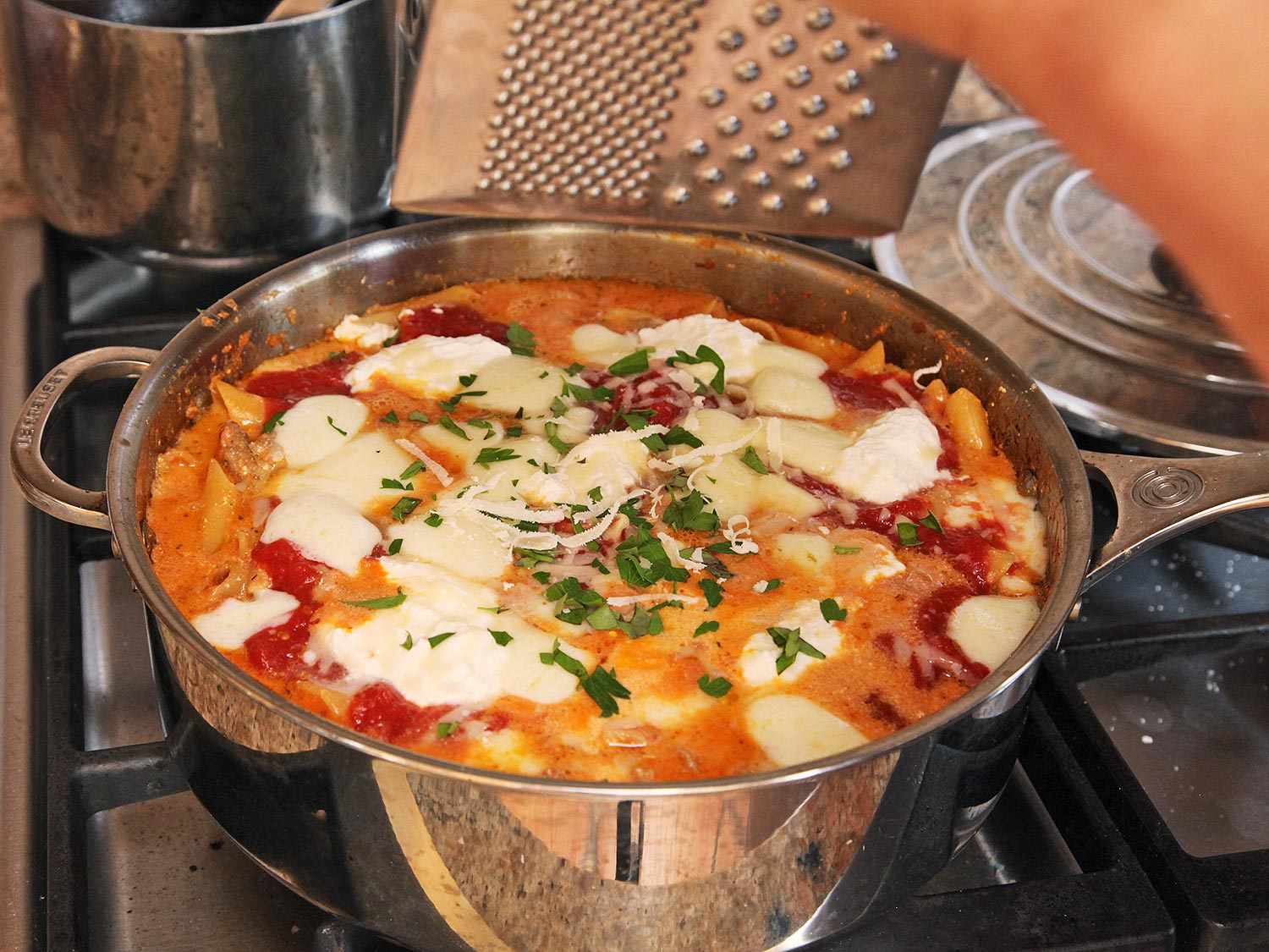 一个装满意大利面，番茄酱和奶酪的煎锅。