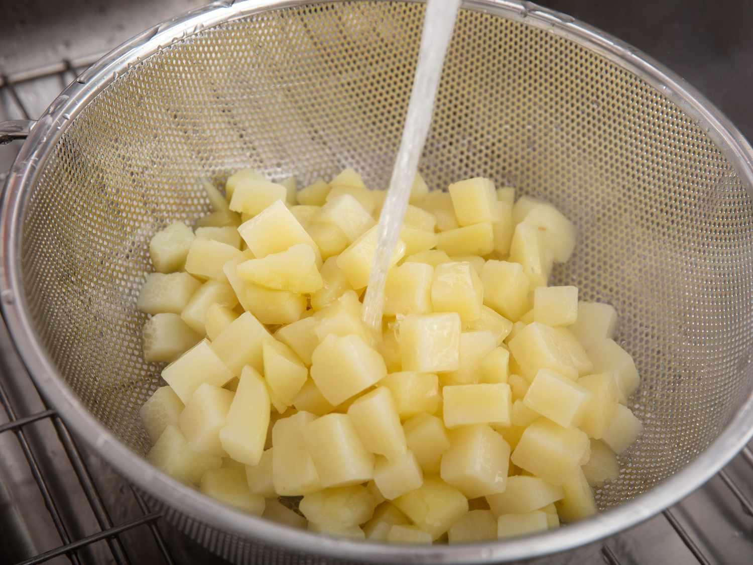 用自来水冲洗煮熟的土豆。