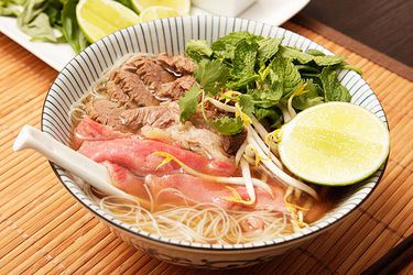 Bowl of 1-hour pho loaded with beef and garnishes