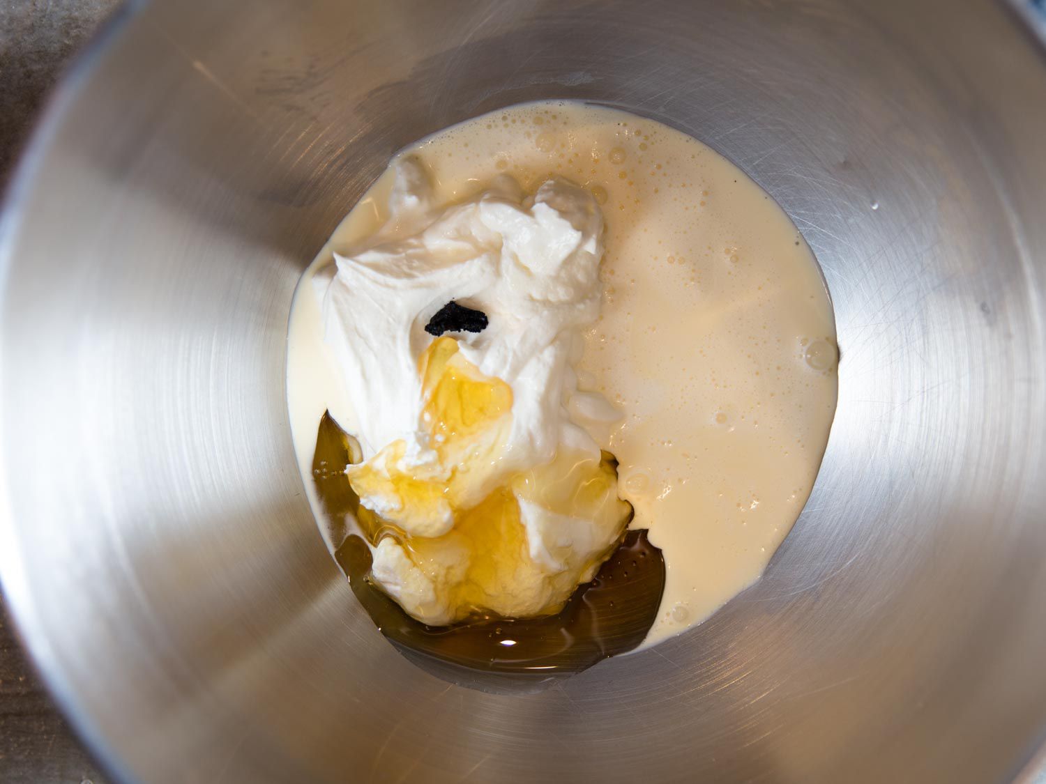 希腊酸奶、奶油、香草籽和金色糖浆放在一个金属碗里gydF4y2Ba