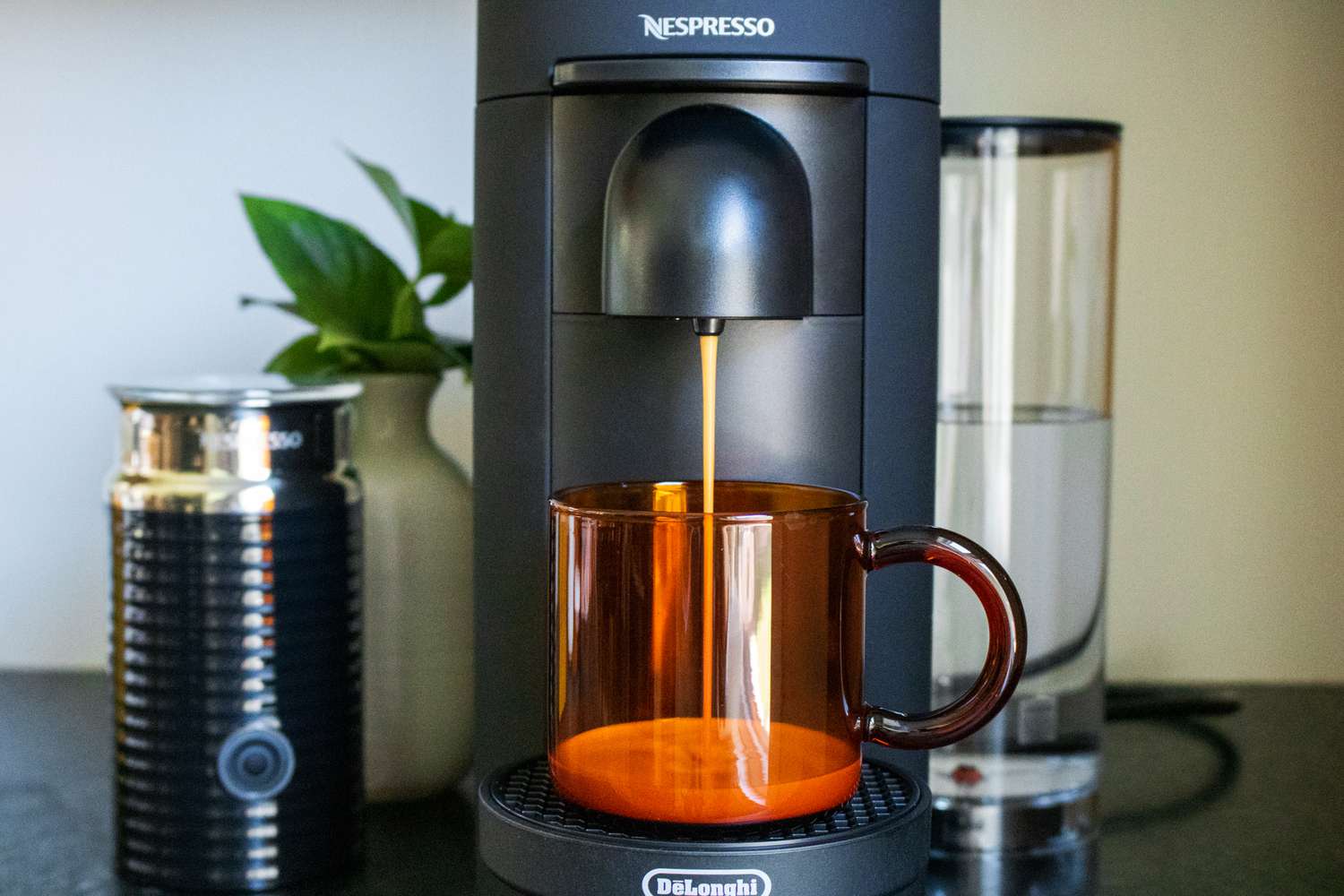 一台Nespresso咖啡机正在把一杯咖啡冲入一个琥珀色的马克杯