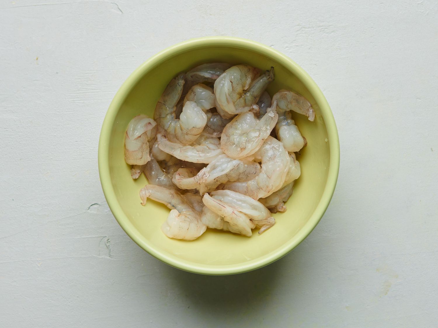 虾，小苏打，一茶匙盐，四分之一杯水混合在一个黄色的小碗里。