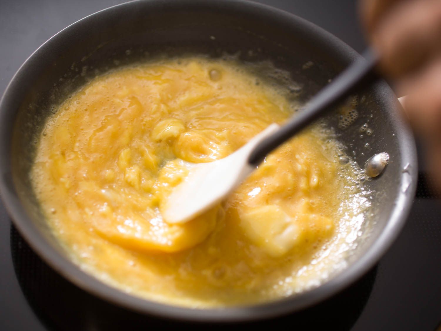 用硅铲在不粘锅中搅拌软炒蛋。