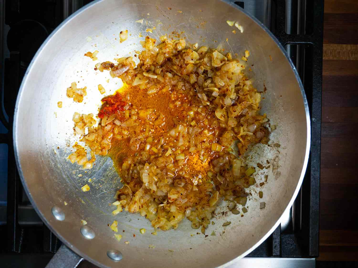 洋葱丁sautéing在锅中加入橄榄油，由于大量的辣椒而染成深橙色，如果所有使用的辣椒都是辣的，这是不可能的(或明智的)