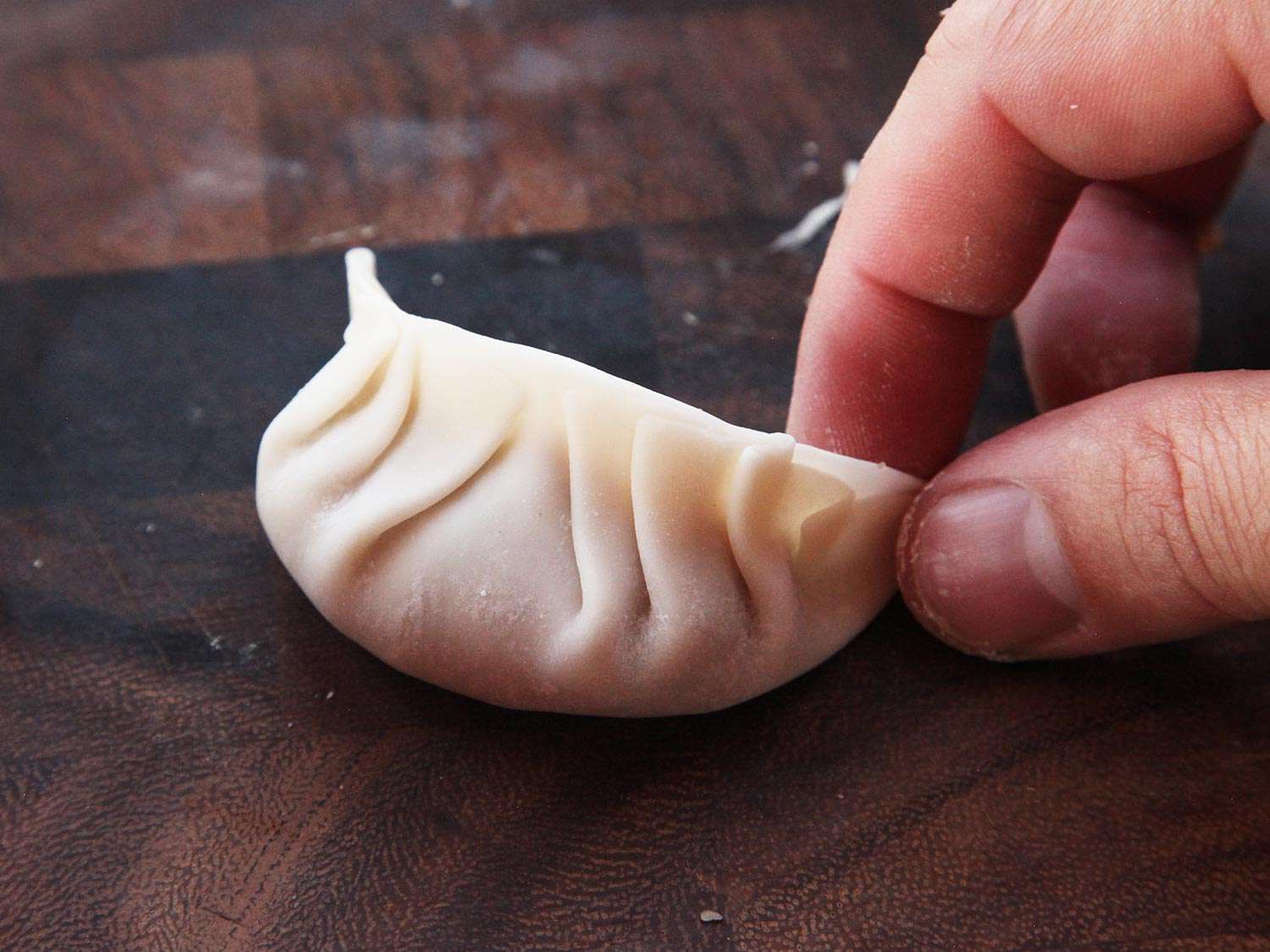 填充和塑造一个刚刚填充和折叠的日式饺子。