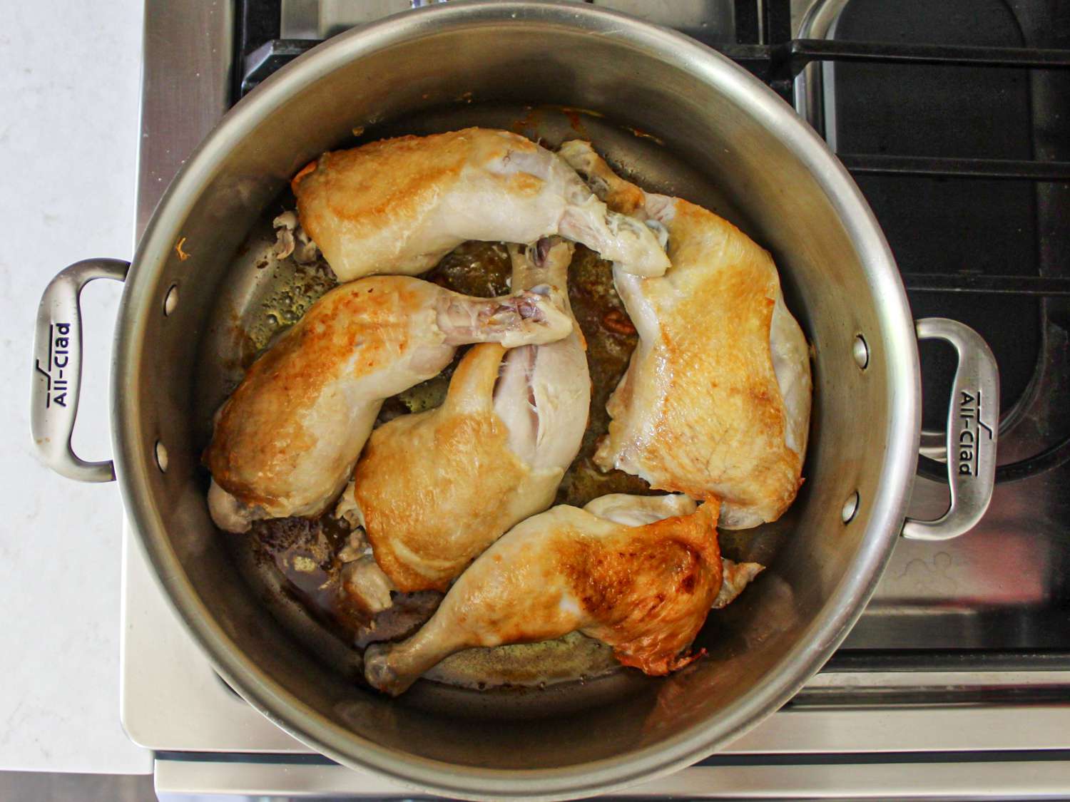 鸡肉，带皮的一面朝下，在炉子上的锅里煮