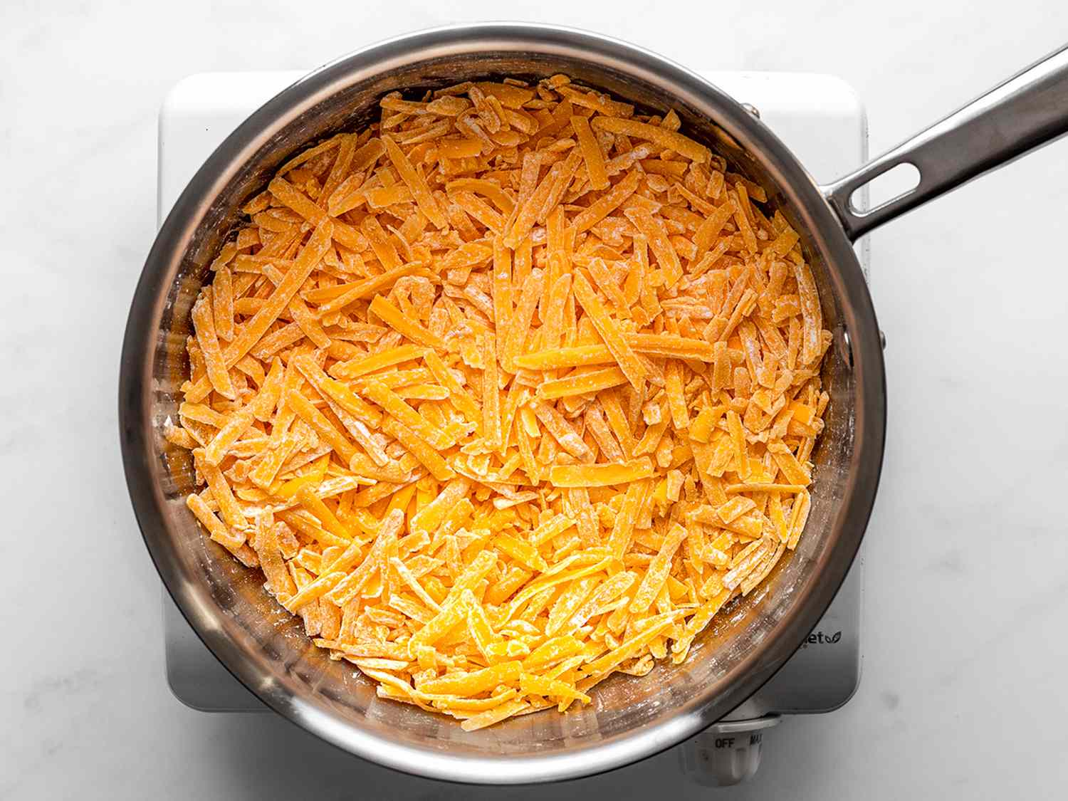 一幅拼贴画，展示了在平底锅里混合的碎奶酪和淀粉。