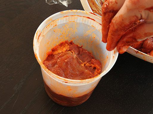手工分层腌制猪肉在夸脱大小的熟食容器。