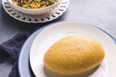 Eba plated next to a bowl of egusi soup