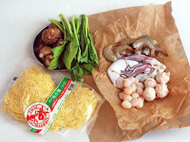 开云体育波胆在白色台面上煎面的材料包括鱼丸、扇贝、鱿鱼和海鲜虾;香菇和青菜为蔬菜;还有包装好的面条。