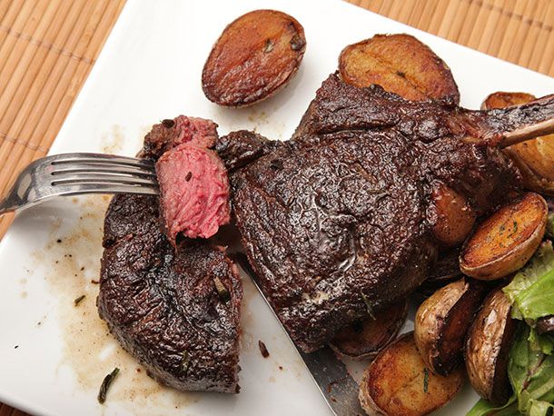 一叉半熟的肉，从涂了黄油的野牛肋骨牛排上切下来，配上酥脆的土豆。