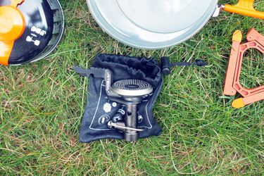 fuel, camping pot, camping stove and stand on grass