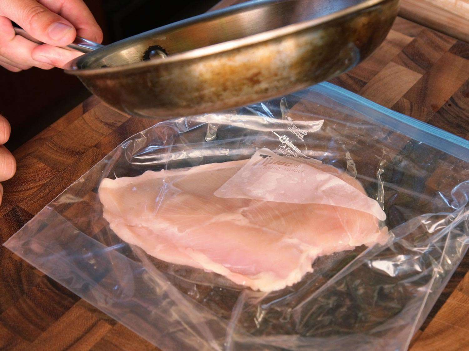 Pounding chicken breast in resealable plastic bag with heavy bottom frying pan