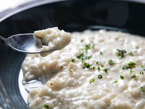 A bowl of risotto sprinkled with chopped chives.