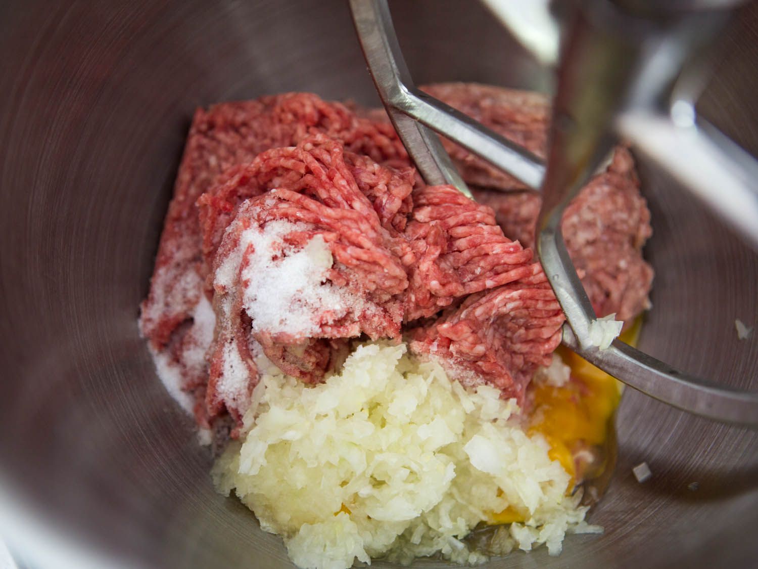 生牛肉，猪肉，盐，鸡蛋和切碎的洋葱放在瑞典肉丸的搅拌器里。gydF4y2Ba