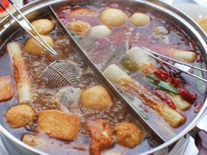 中国火锅装满汤,鱼丸、豆腐和蔬菜