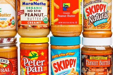 An assortment of different brands of creamy peanut butter jars.