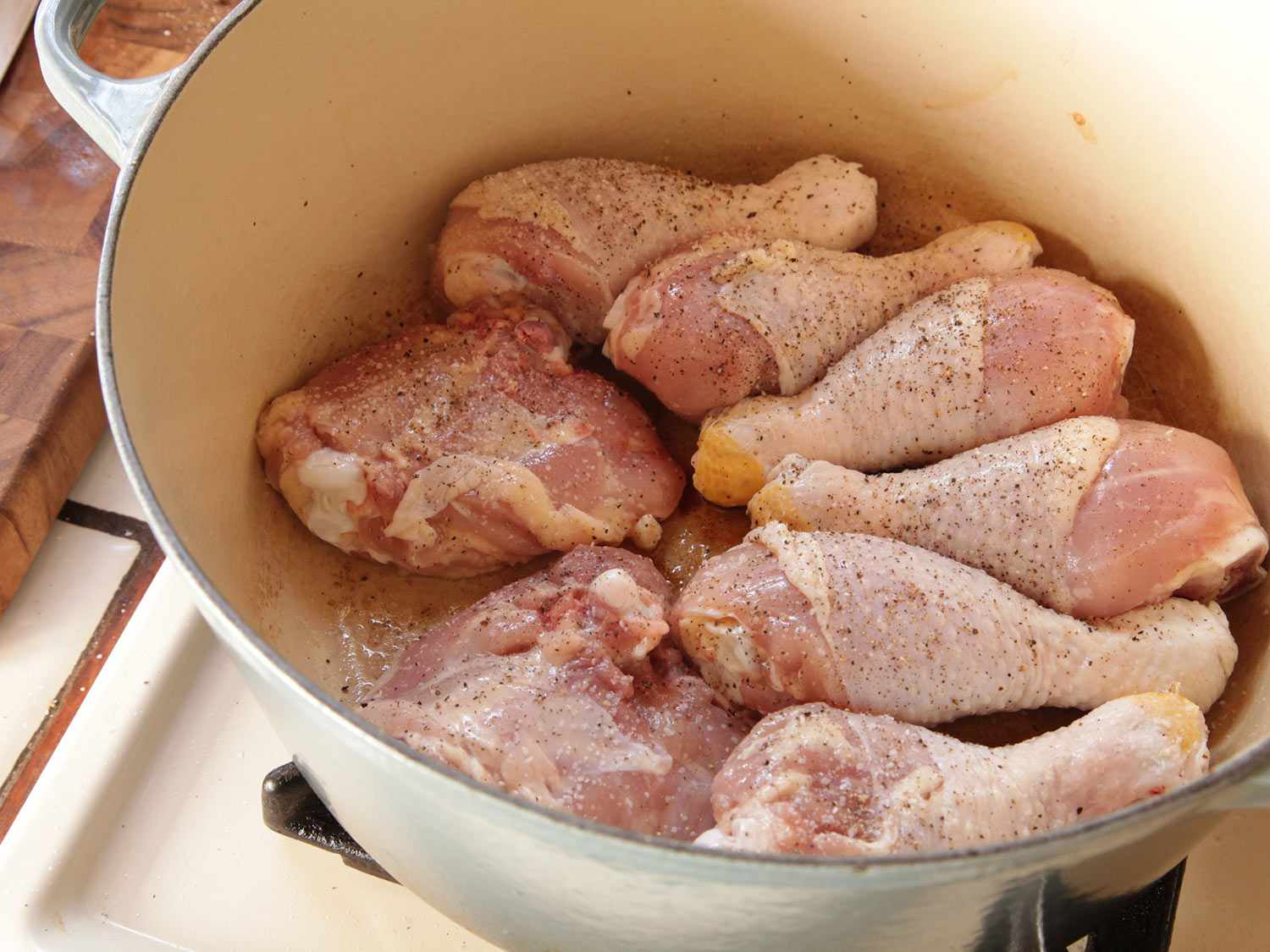 把带骨的鸡腿和鸡腿放在荷兰烤箱里做豆焖汤。