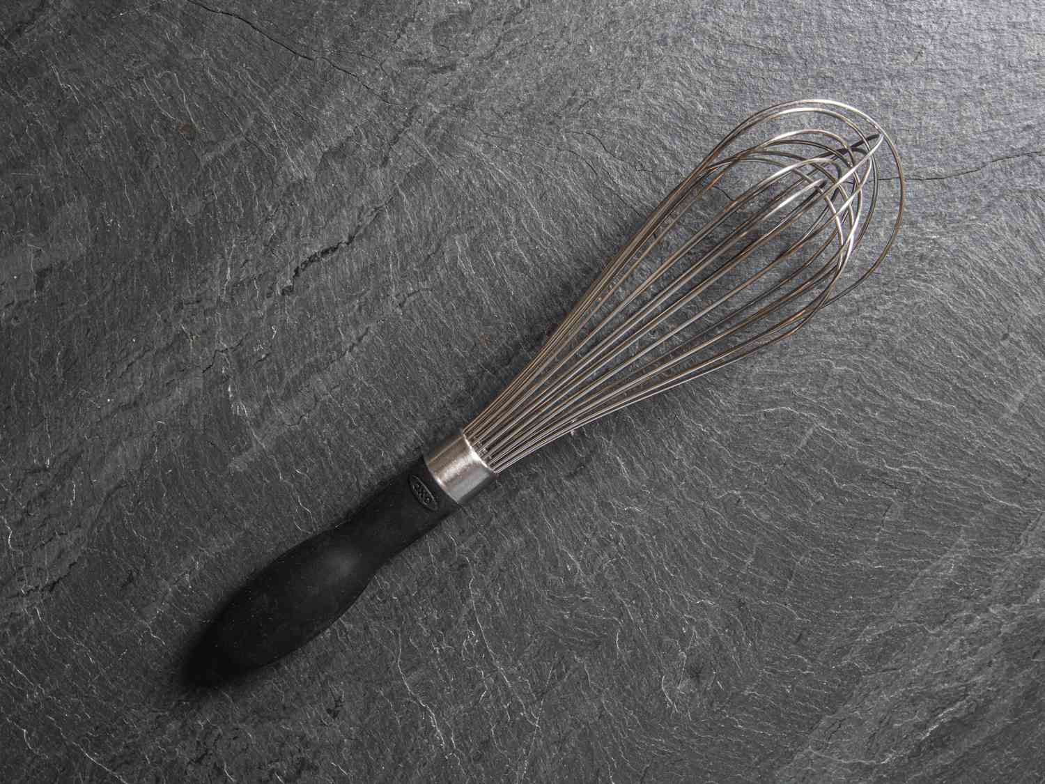 The OXO balloon whisk on a slate gray surface