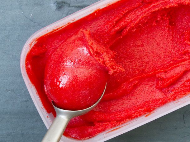 一桶红色的冰沙和一个冰激凌勺。