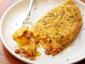 diner-style火腿和奶酪煎蛋白色板,撒上香葱。叉子是提升一点omelette. -美国-煎火腿和奶酪- 23. jpg