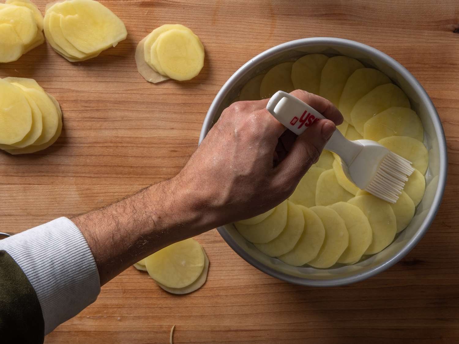 在土豆片上刷上透明黄油。