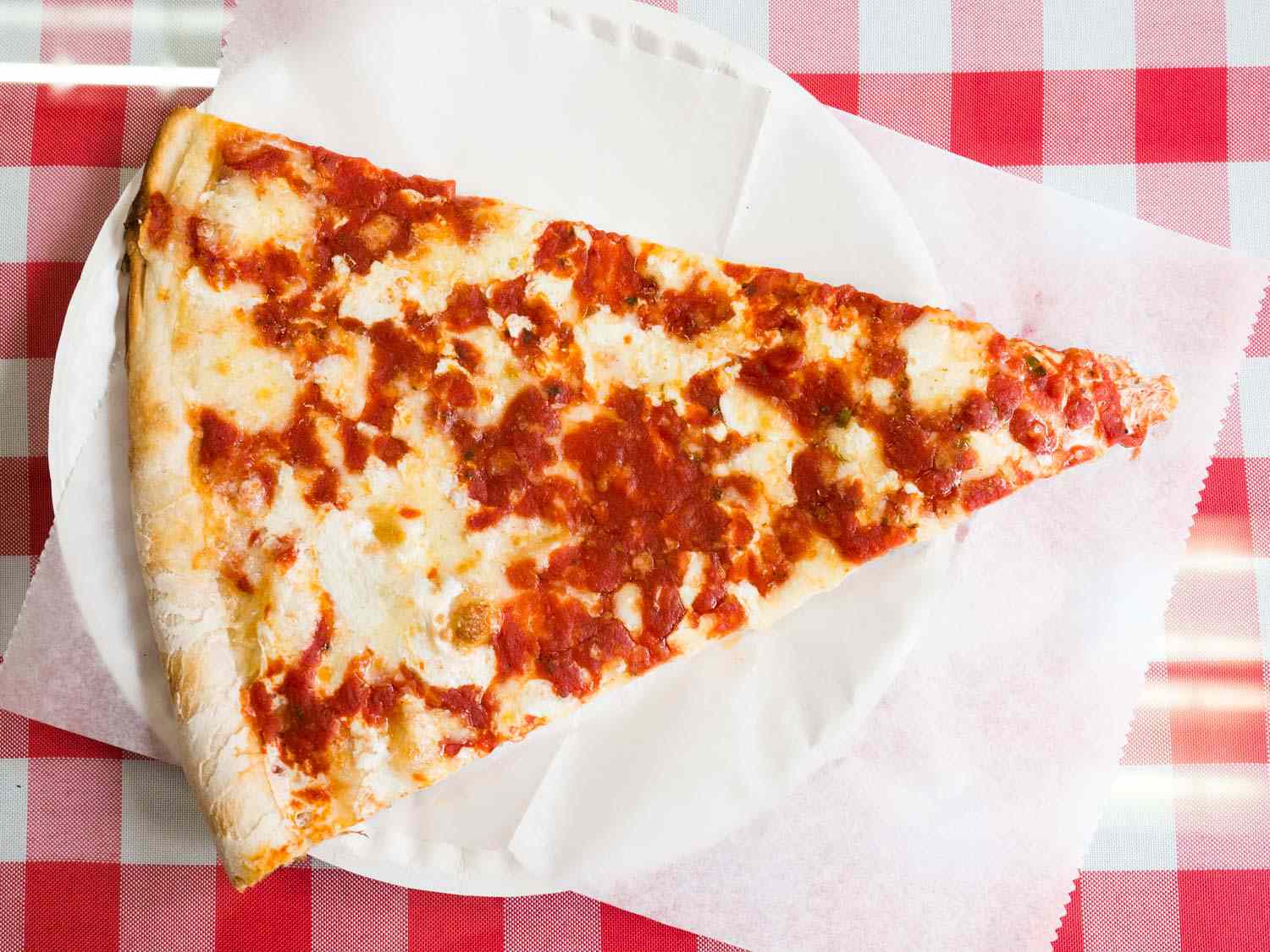 一块纽约披萨放在纸盘子里。