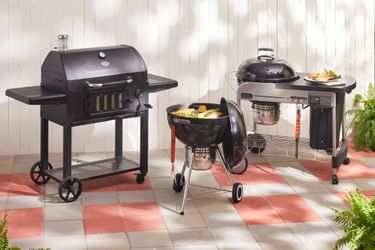 three charcoal grills on a patio