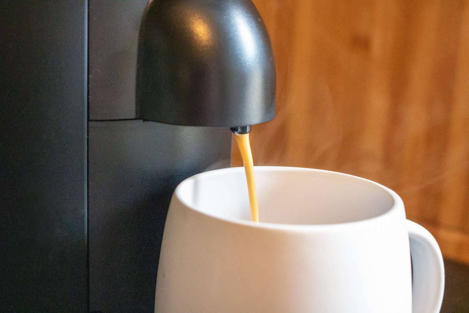 一个雀巢咖啡机冲进白色马克杯的特写镜头