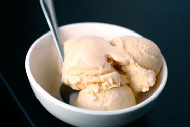 Three scoops of vanilla New England-style ice cream in a white bowl.