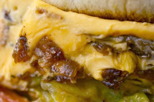 A close up of the caramelized onions and cheese on a Animal Style Double-Double In-N-Out hamburger.