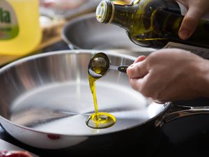 在煎锅中倒入一汤匙橄榄油，测试用橄榄油进行高温烹饪是否合适。