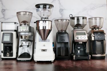 六个咖啡研磨机联合起来反对一个大理石的背景