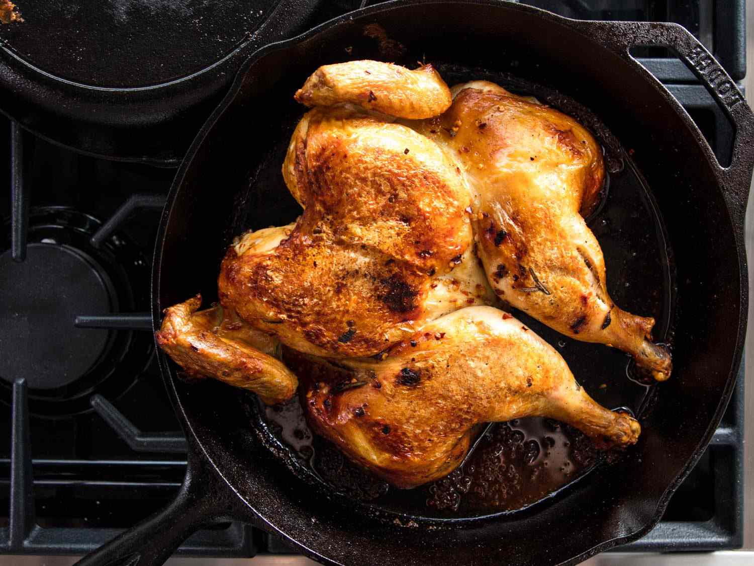 把鸡肉放在铸铁煎锅的砖下。
