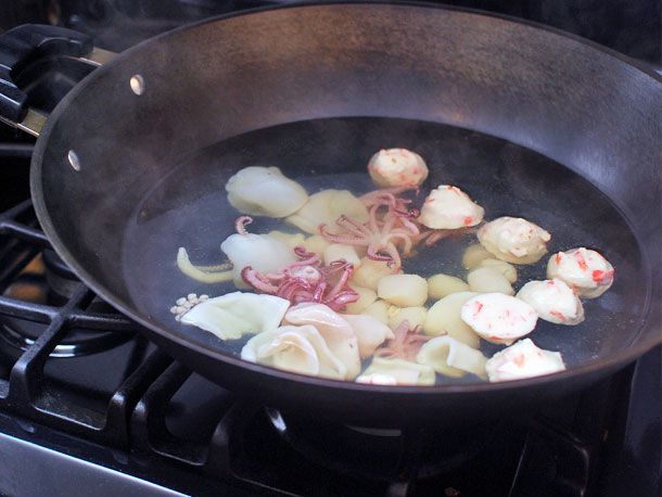 鱿鱼、鱼丸和扇贝在锅里煮半熟。