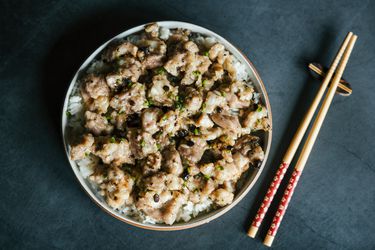 俯视图蒸排骨在一盘米饭旁边放置一双筷子。