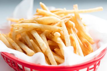 McDonald's-style thin and crispy french fries in plastic basket.